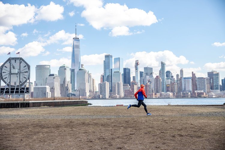 A runner in Jersey City with the Colgate Clock and the Lower Manhattan skyline in the background